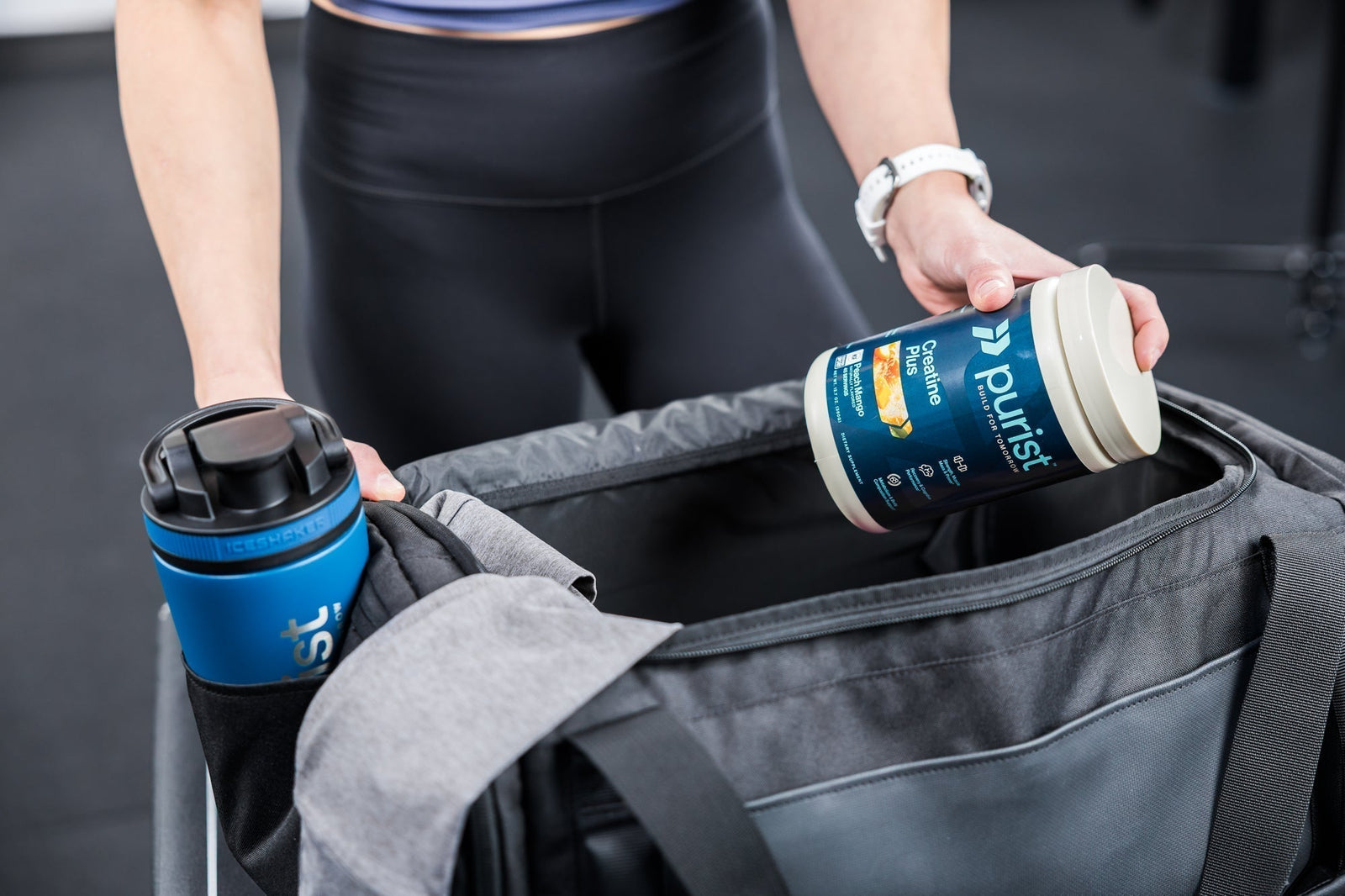 An athlete places pre-workout tub into a gym bag