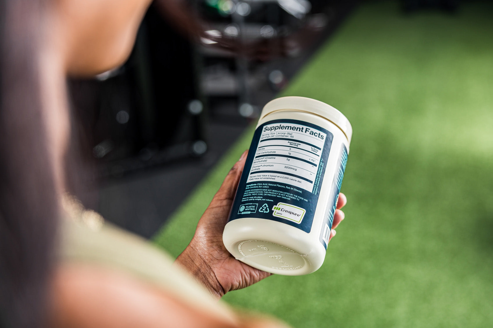 Person holding a Purist supplement container with a blurred background